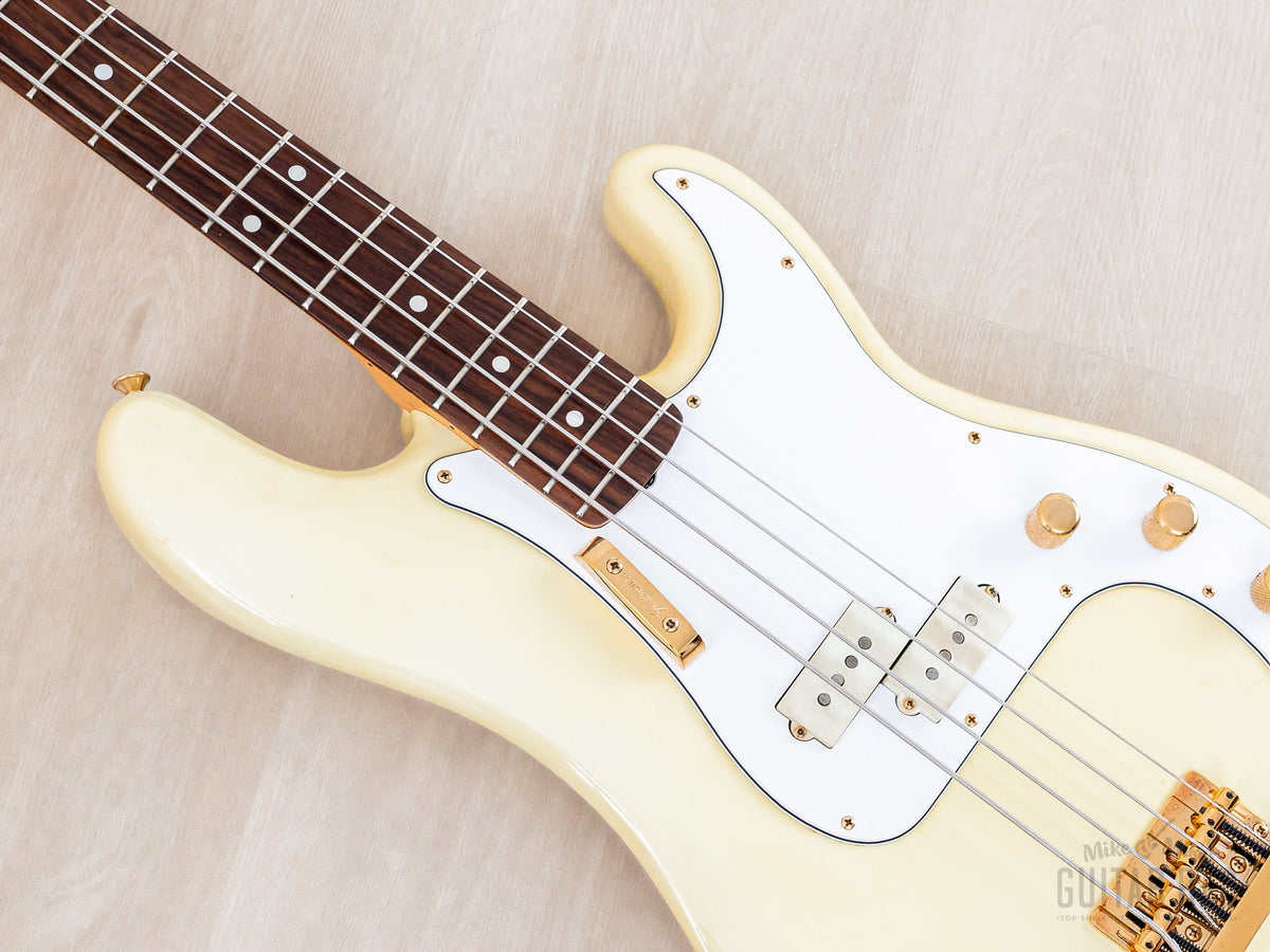 Close-up of white pickguard, pickup and gold knobs